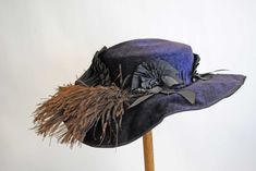 "EDWARDIAN VELVET LADIES WIDE BRIMMED HAT, LABEL, c1906 A circa 1905 hat from the Edwardian period. A dark navy blue plush velvet with raised nap, wide brimmed with dark brown feathers.  With large flat top crown, with a black grosgrain ribbon band and gathered accordion pleating decorations and with brown feather plumes that adorn the brim. Black cotton forms the gathered string lining.  Label Reads: M. BLUMBERG & SONS, 106 BROUGHTON ST. W., SAVANNAH, GA.  This hat would make a lovely addition Wide Brimmed Hat, Antique Hats, Velvet Hat, Brimmed Hat, Antique Textiles, Savannah Ga, Dark Navy Blue, Wide Brimmed Hats, Brim Hat