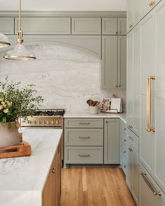 a kitchen with marble counter tops and wooden flooring is shown in this image, there are gold pulls on the cabinets