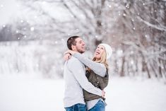 a man and woman are hugging in the snow