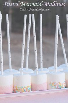 there are marshmallows on the table with sticks sticking out of them