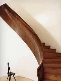 a chair sitting in front of a wooden stair case