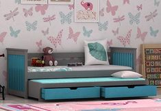 a child's bedroom with pink and blue butterflies on the wall, gray daybeds