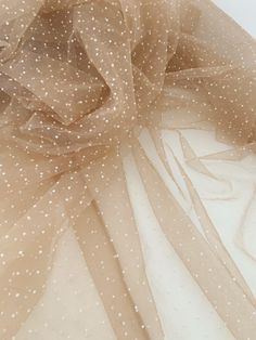 a white and beige polka dot sheer fabric