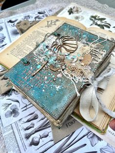 an altered book is sitting on top of some papers and other things to make it look like