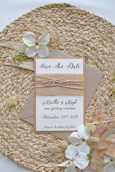 the wedding stationery is laid out on top of a woven placemat with flowers