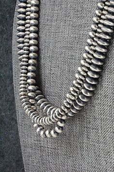 This three-strand sterling silver Navajo Pearl necklace was made by Navajo silversmith Dorinda Mariano. The cones are stamped sterling.Necklace: 20"Bead sizes:3/16" x 5/16" (5mm x 8mm)3/16" x 1/4" (5mm x 6mm)1/8" x 3/16" (3mm x 5mm)Free shipping on all orders! We ship with USPS and always include tracking. All orders ship within a day of payment.Returns are accepted up to 30 days after you receive your order. Just send us a message. Our shop offers cash back or store credit. The item must be returned in new condition. Artisan Double Strand Silver Necklaces, Artisan Double Strand Silver Necklace, Artisan Silver Double Strand Necklace, Western Style Silver Jewelry With Silver Beads, Artisan Silver Double Strand Jewelry, Silver Artisan Necklace With Concho, Artisan Silver Necklace With Concho, Silver Southwestern Concho Necklace, Southwestern Silver Concho Necklace