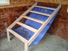 a wooden bed frame sitting in the corner of a room next to a brick wall