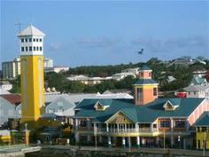 a yellow and white clock tower in the middle of a city with lots of buildings