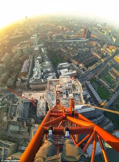 a man is standing on top of a tower with his feet up in the air