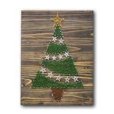 a christmas tree made out of grass on top of a wooden board with gold stars