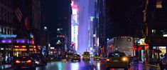 a city street filled with lots of traffic next to tall buildings and neon lights at night