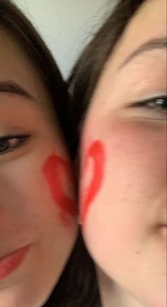 two women with red letters painted on their faces