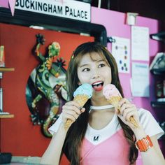 a woman holding two ice cream cones in her hands