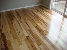 an empty room with hard wood floors and sliding glass doors that lead to a deck