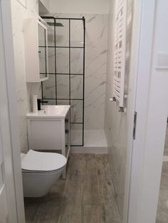 a white toilet sitting next to a walk in shower