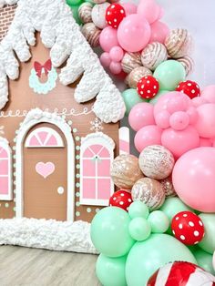 a gingerbread house is decorated with balloons