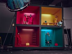 three dolls are standing in the middle of a multi - colored cubed room with lights on