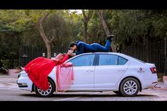 a man and woman leaning on the hood of a white car