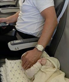 a man holding a baby in an airplane seat