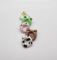 five different colored plastic animals on a white surface