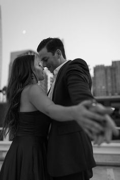 a man and woman standing next to each other in front of a cityscape