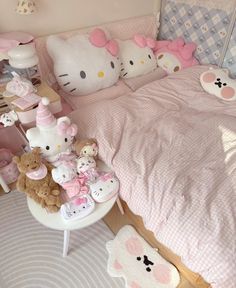 a hello kitty themed bedroom with pink bedding and teddy bears on the side table