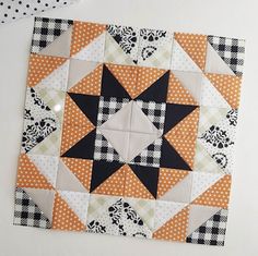 an orange and black patchwork quilt on a white wall with the words woodberry way below it