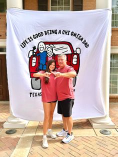 two people standing in front of a banner