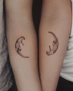 two people with matching tattoos on their arms, one is holding the other's arm