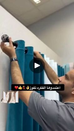 a man is painting the wall in his office with blue rollers and white paint