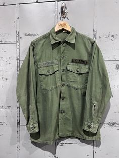 70's OG-107 Fatigue Button Up Shirt- Vietnam War(Army Green)  Distressed vintage condition. See pictures for condition 15.5x33. Please review measurements as some vintage items fit smaller than modern sizing. Measurements taken with garment laid flat: 21" across from armpit to armpit 27" length from shoulder to hem 22.5" sleeve from shoulder to hem Please send a message if you have any questions. Double check measurements and inspect all pictures carefully before purchasing. Orders ship via USPS Vintage Green Shirt, Vintage Long Sleeve Tops With Pockets, Vintage Long Sleeve Tops With Buttons, Vintage Long Sleeve Shirt With Buttons, Vintage Cotton Shirt With Pockets, Vintage Green Tops With Pockets, Green Vintage Tops With Pockets, Vintage Collared Khaki Tops, Vintage Khaki Top With Pockets