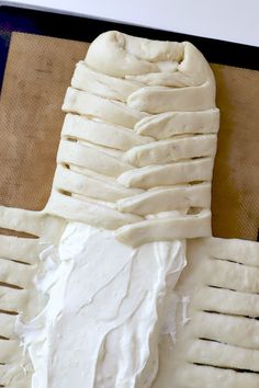 the bread has been made to look like it is wrapped in white paper and sits on a baking sheet