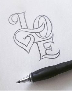 a pen is laying on top of a piece of paper with the word love written in it