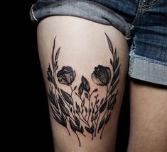 a woman's thigh with flowers and leaves tattooed on her leg, which reads ide tattoos