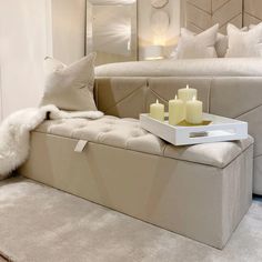 a white couch with candles on it in front of a large mirror and sofa bed