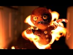 a stuffed animal sitting on top of a fire with eyes wide open and one hand in the air