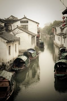 there are many boats that are in the water on this street and one boat is going down the canal