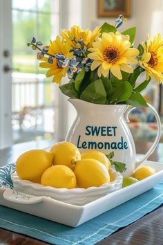 a white pitcher filled with yellow flowers and lemons