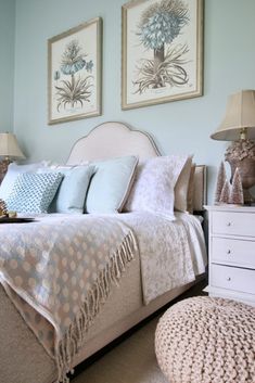 a bedroom with two pictures above the bed and pillows on the headboard in front of the bed