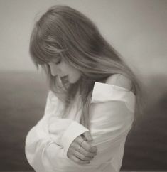 black and white photograph of a woman with her hair blowing in the wind looking down