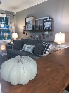 a living room filled with furniture and a large wooden table in front of a window