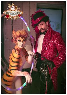 two people dressed up in costumes posing for a photo with one holding a hoop and the other wearing a tiger costume