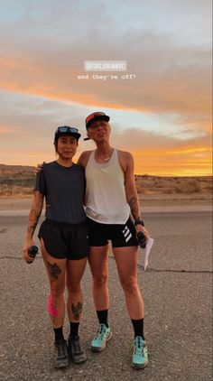 two people standing next to each other on a road