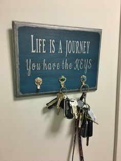 a key holder with keys hanging from it and a sign that says life is a journey you have the keys