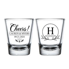 two shot glasses with the words cheers and laurels on each one, both engraved in black