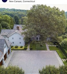 an aerial view of a large house surrounded by trees and hedges in the foreground