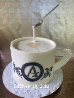 a coffee cup with a spoon sticking out of it's side sitting on top of a doily