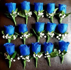 blue roses are arranged in rows on a leather surface with baby's breath flowers