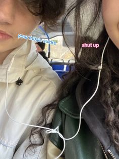 two people sitting in a car with ear buds attached to their ears