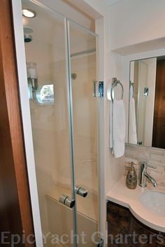 a bathroom with a sink, shower and mirror